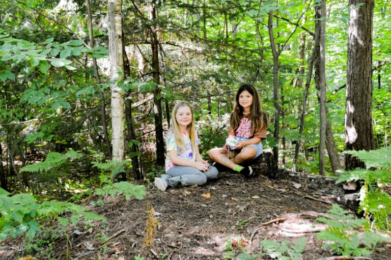 Two girls sitting in a forest