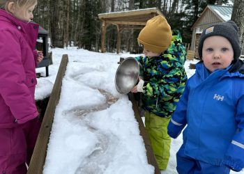 Children pouring water on snowy ramp Tiffin Nature Program