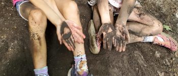 Two pairs of hands in dirt