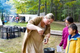 Two children making candles at Festival at Fort Willow
